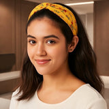 Bandeau cheveux AuroraFlora jaune fleuri porté sur cheveux longs avec design croisé élégant.