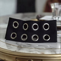 Bandeau cheveux EyeLoom noir avec œillets métalliques en gros plan.