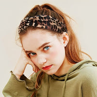 Bandeau cheveux – femme posant avec un bandeau noué motif léopard au style affirmé