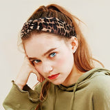 Bandeau cheveux – femme posant avec un bandeau noué motif léopard au style affirmé