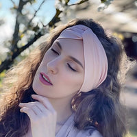 Bandeau cheveux large pastel maintenant les cheveux d’une femme en arrière