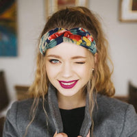 Bandeau cheveux – femme souriante portant un bandeau noué floral retenant les cheveux longs vers l’arrière