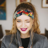 Bandeau cheveux – femme souriante portant un bandeau noué floral retenant les cheveux longs vers l’arrière