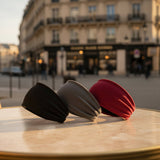 Bandeaux cheveux présenté en lot de trois  couleurs, noir, gris et rouge, sur une table d'un cafe parisien. 