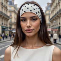 Bandeau cheveux Polka Élan blanc à pois noirs porté en ville, style élégant et féminin.