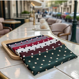 Bandeau cheveux Polka Élan – pack complet 6 couleurs à pois (vert, marron, blanc, rouge, gris, noir), posé sur comptoir restaurant, style chic quotidien.