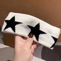 Bandeau cheveux StarPulse blanc à étoiles noires présenté en gros plan.