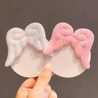 Barrette cheveux kawaii ailes d’ange rose et blanc tenues en main