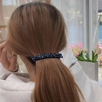 Barrette cheveux CrystalMuse fixant une coiffure élégante sur cheveux longs d’une femme.