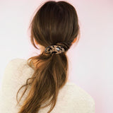 Barrette cheveux léopard sécurisant une demi-queue chic sur cheveux longs.