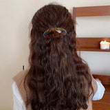 Barrette cheveux marbrée ovale sublimant une coiffure féminine.