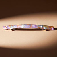 Barrette cheveux multicolore présentée en studio sur fond élégant.