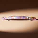 Barrette cheveux multicolore présentée en studio sur fond élégant.