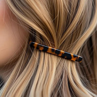 Barrette cheveux effet panthère maintenant une mèche de cheveux sur le côté.