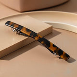 Barrette cheveux motif panthère présentée en gros plan sur fond élégant.