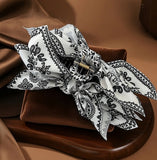 Pince cheveux BandBow blanc avec motifs noirs paisley en gros plan studio.