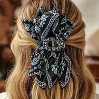 Pince cheveux BandBow retenant des cheveux longs blonds avec un nœud bandana volumineux.
