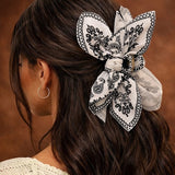 Pince cheveux BandBow sublimant une coiffure statement avec un nœud papillon volumineux.