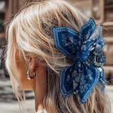 Pince cheveux BandBow fixant une coiffure arrière avec un nœud satiné paisley noir et blanc.