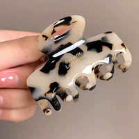 Pince cheveux motif léopard beige présentée en gros plan dans une main.