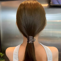 Pince cheveux MetalTwist assurant une fixation élégante sur cheveux longs d’une femme.