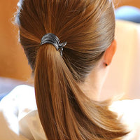 Pince cheveux MetalTwist sublimant une coiffure urbaine avec un design spiral métallique.
