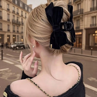 Pince cheveux VelourGrip en velours noir fixant un chignon élégant d'une femme urbaine.