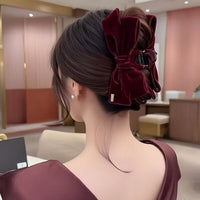 Pince cheveux VelourGrip en velours rouge, sublimant un chignon d'une femme élégante.