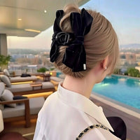 Pince cheveux VelourGrip en velours noir structurant une coiffure chic d'une femme.