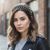 Serre tete SpikeAura noir maintenant les cheveux d’une femme avec un look rock chic.