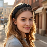 Serre tete UrbanTwist noir porté par une femme fixant les cheveux mi-longs vers l’arrière.