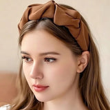 Serre tete UrbanTwist marron café porté par une femme avec coiffure structurée.